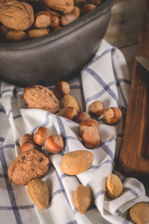 Walnuts, hazelnuts, peanuts and nuts on wooden table.の写真素材