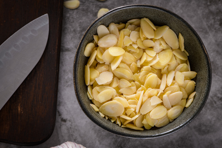 Almonds in dark bowl on kitchen countertop. The concept of food, healthy food.の写真素材