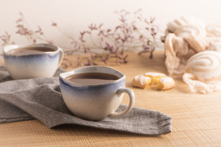 Coockies with egg white cover. Portuguese sweets known as cavacas served with tea on ceramic cups.の写真素材