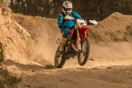 Enduro bike rider on action. Turn on sand terrain.