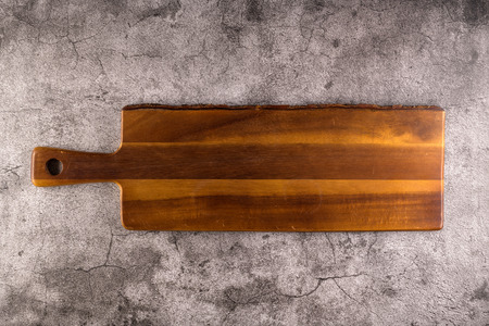 Wooden empty tapas tray board on dark black cement background.