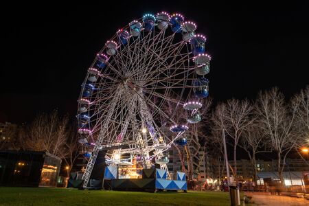AVEIRO, PORTUGAL - CIRCA DECEMBER 2018: Fonte Nova's garden with Christmas market and colored ferris wheel near Ria de Aveiro at night.のeditorial素材