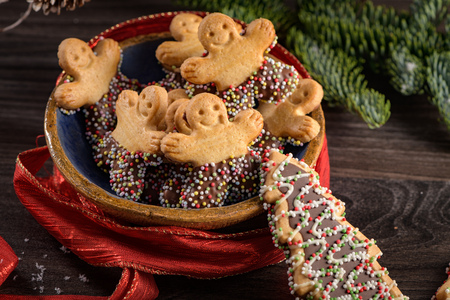 Christmas holiday background with gingerbread cookies, candy canes and evergreens over wooden table....
