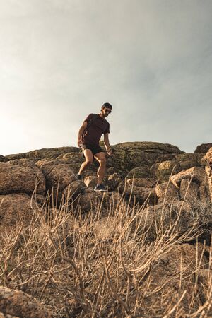 Traveling Man tourist with backpack hiking in mountains landscape active healthy lifestyle adventure vacations on rocky mountain.の写真素材