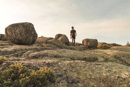 Traveling Man tourist with backpack hiking in mountains landscape active healthy lifestyle adventure vacations on rocky mountain.の写真素材