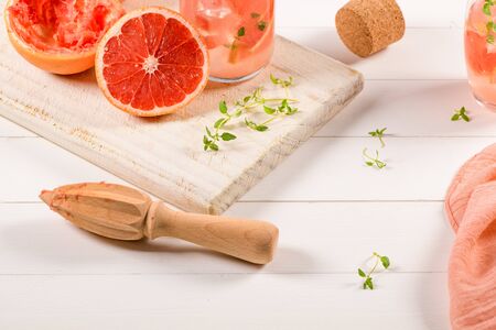Healthy summer drink grapefruit lemonade with thyme in glasses with ice on a wooden surface.の写真素材