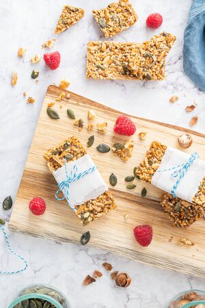 Organic homemade granola bars on rustic marble stone kitchen countertop.