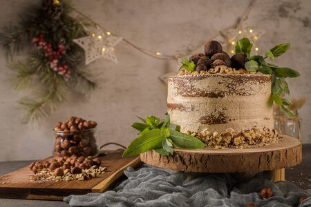 Delicious naked coffee and hazelnuts cake on table rustic wood kitchen countertop.の写真素材
