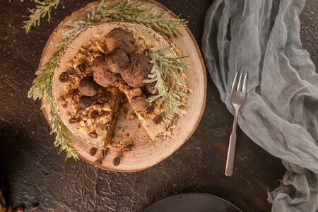 Slice of delicious naked coffee and hazelnuts cake on table rustic wood kitchen countertop.の写真素材