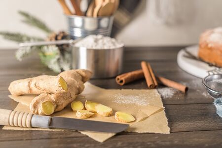Ginger root and sliced on old kitchen countertop.
