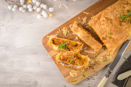 Puff pastry vegetable roll on kitchen decorated countertop.
