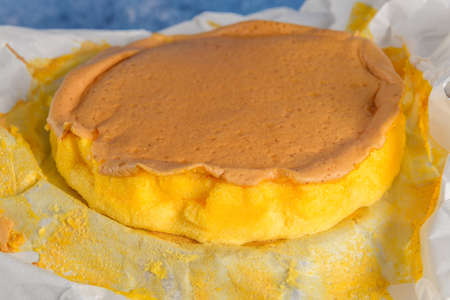 Portuguese sponge cake wrapped in the typical paper used on the baking, on wooden background with...