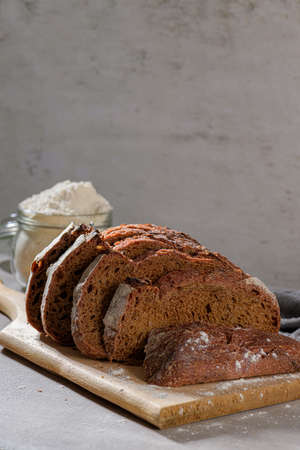 Slices of homemade beetroot bread, and crispy wheat and rye bread. On a wooden board.