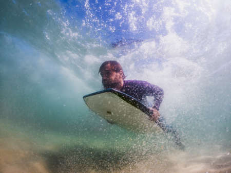 Bodyboarder duck diving a wave in Furadouro beach, Ovar - Portugalの写真素材