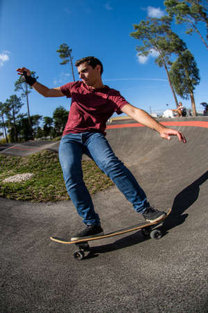 Skateboarder practice on a pump track park on a sunny day.の写真素材
