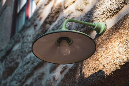 Green ld industrial style lamp on granite wall.の写真素材