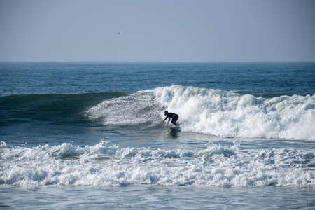 Surfer in action on the ocean waves on a sunny day.