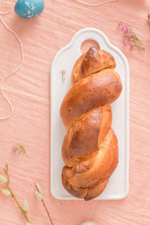 Portuguese traditional Easter cake. Folar with eggs on easter table. Blossom flowers and colorful...