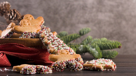Christmas holiday background with gingerbread cookies, candy canes and evergreens over wooden table....