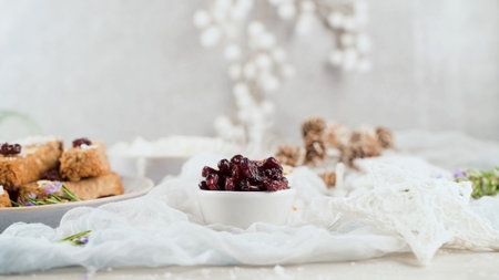 Cereal bars with almonds, coconut and cranberries on a Christmas season table decorated with lights and stars.の写真素材