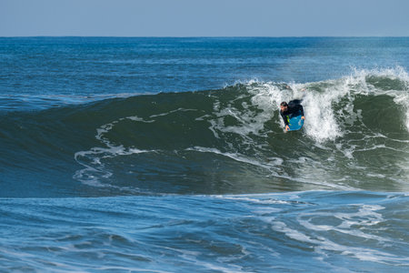 Bodyboarder surfing ocean wave on a sunny winter day.の写真素材