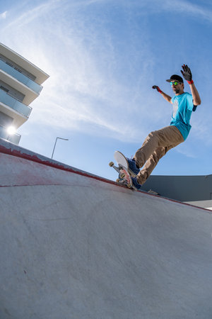 Skateboarder doing frontside five-o grind trick in concrete skatepark.