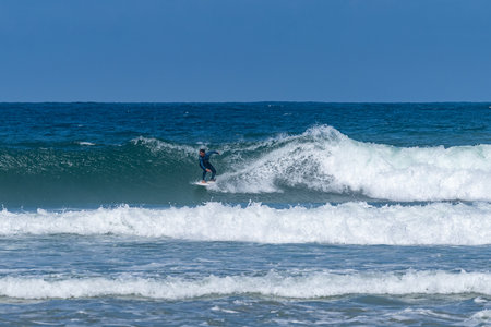 Surfer riding waves in Furadouro Beach, Portugal. Men catching waves in ocean. Surfing action water...