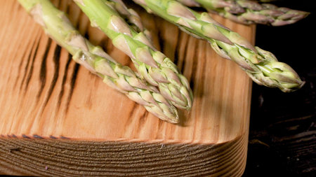 Fresh green asparagus on dark wooden table.の写真素材