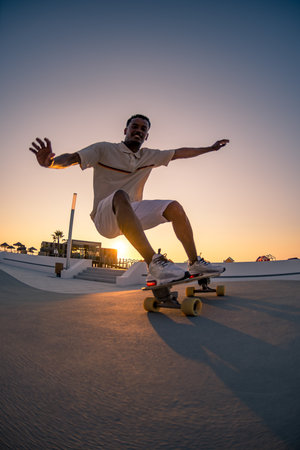 Surf skater training surfing moves near the beach at sunset.の写真素材