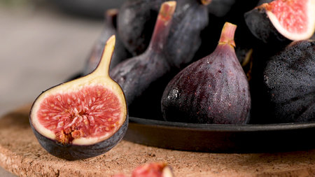 A few figs in a plate on an modern concrete counter top with dark ceramic modern vases in the...