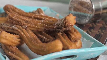 Traditional churros with hot chocolate dipping sauce on wooden counter top.の写真素材