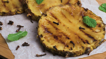 Grilled pineapple slices on wooden table.の写真素材