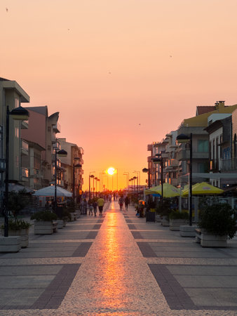 OVAR, PORTUGAL - JULY 9: Tourists walking on Furadouro Beach main street during sunset. Tourism is a fundamental economic activity in Portugal.のeditorial素材