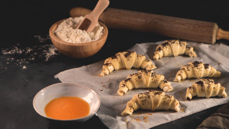 Raw croissant with ingredients on a kitchen countertop.