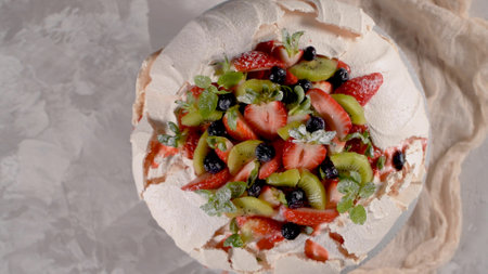 Pavlova cake with fresh blueberries, strawberries and kiwi.の写真素材