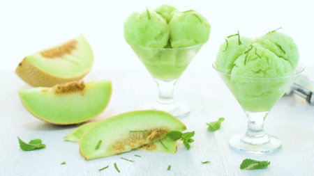 Close up of melon flavored ice-cream with mint and melon on a white table.の写真素材