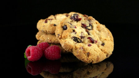 Dried fruits chip cookies and raspberries isolated on black background.の写真素材