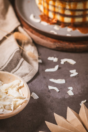 Delicious caramel cake with small pieces of pecan nuts and coconut shavings.の写真素材
