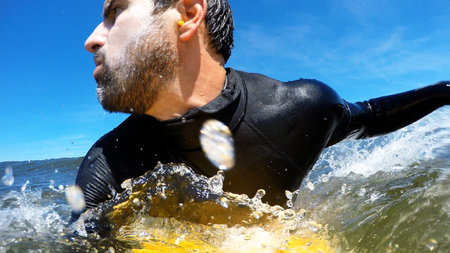 Young man enjoying the surfing in waves.