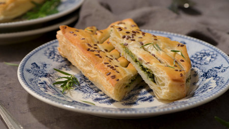 Typical Portuguese snack with spinach. Spinach puff pastry with ricotta cheese, know as spinach puff pastry with ricotta cheese on old fashioned ceramic plates.の写真素材