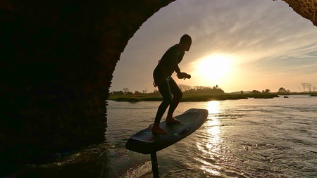 Hydrofoil rider gliding over the water with his board in one of the canals of the Ria de Aveiro in...