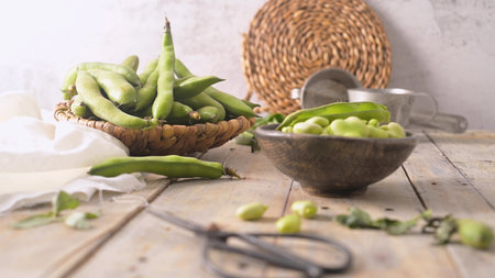 Fresh and raw green broad beans on wooden table.の写真素材