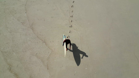 Aerial shot of a surfer walking on sandy beach, Murtosa, Aveiro - Portugal.の写真素材