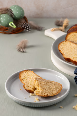 Sweet Easter bread slices on a plate, golden crust and fluffy interior, with festive decorations...