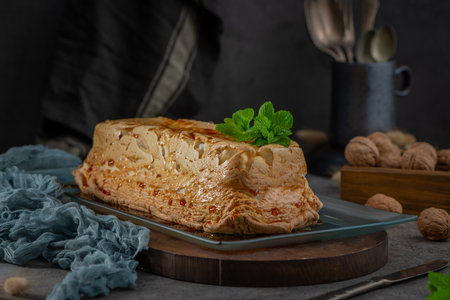 A whole molotof, a traditional caramelized egg white pudding, generously drizzled with sweet syrup and garnished with fresh mint leaves, is presented on a rectangular glass plateの写真素材