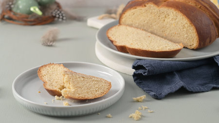 Traditional Portuguese Easter bread Folar on plates with a blue cloth and Easter decorations offers...