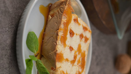 A tempting, individual portion of caramelized pudding, drizzled with sweet caramel and garnished...