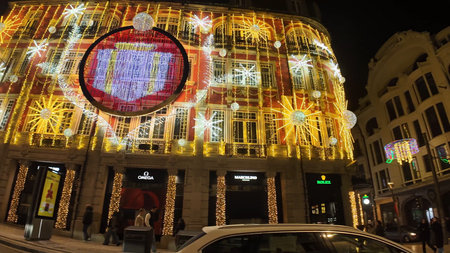 PORTO, PORTUGAL - NOVEMBER 30, 2025: A grand, multi-story urban building in Porto is lavishly decorated with brilliant yellow Christmas string lights and large, white snowflake motifs across its facade at night.のeditorial素材