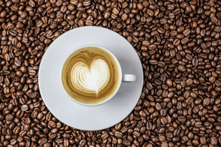 Hot coffee in the coffee beans with latte artの写真素材