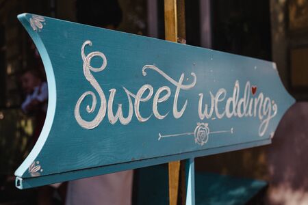 Sweet Wedding Blue Sign. The words sweet wedding are painted a sign with a directional arrow.の写真素材